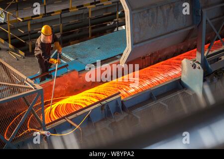 --FILE--un lavoratore cinese produce rotoli di acciaio di rinforzo per le aste possono essere esportate in un impianto siderurgico in Lianyungang city east Chinas provincia dello Jiangsu, 1 Foto Stock