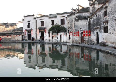 I turisti sono visibili nella parte anteriore di edifici tradizionali a Hongcun villaggio in Yixian county, Huangshan city east Chinas provincia di Anhui, 22 novembre 2013. Foto Stock