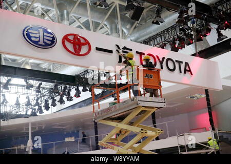 Lavoratori creare lo stand della FAW-Toyota in preparazione per la prossima xiii Beijing International Automotive Exhibition, noto anche come Auto China 2014, Foto Stock