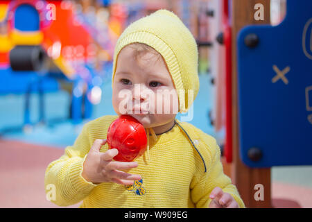 Un bambino di un caucasico caucasico riproduce gli stampi di sabbia in una sandbox. Bambino bambina ragazzo di un anno di età a giocare nel parco giochi del sandbox. Ritratto di Foto Stock