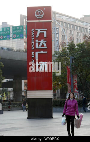 --FILE--A passeggiate a piedi passato un cartello del Wujiaochang Wanda Plaza in Cina a Shanghai, 3 gennaio 2014. Conglomerato Dalian Wanda Gruppo Corp Foto Stock