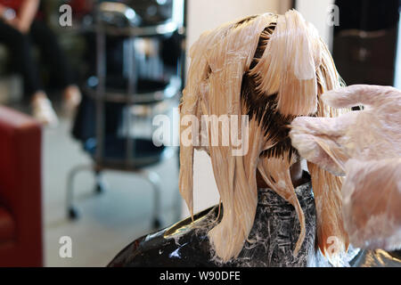 Luce di colore capelli bagnati sono tutta la testa applicando in salone Foto Stock