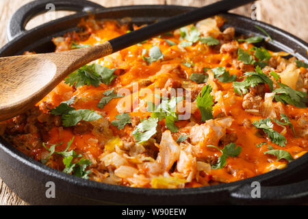 Il cavolo in casseruola con carne di manzo macinata, cipolle e formaggio cheddar close-up in una padella sul tavolo orizzontale. Foto Stock