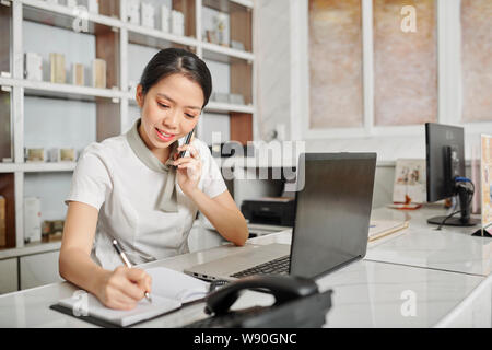 Receptionist rispondendo alle chiamate telefoniche Foto Stock