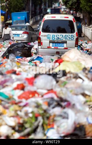 Un minivan è circondato da cumuli di rifiuti a sinistra su una strada in città Shiyan, città di Shenzhen, Cina del sud della provincia di Guangdong, 20 novembre 2014. Cina Foto Stock