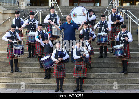 Glasgow, Regno Unito. 12 Ago, 2019. Di Glasgow international festival di tubazioni è iniziata oggi con una prestazione speciale dalla Scottish fuoco e di salvataggio novizio capretti Pipe Band. Ora nel suo sedicesimo anno, Piping Live, è il più grande festival del suo genere attrae 40.000 appassionati di musica, famiglie e appassionati da tutto il mondo per guardare oltre 5.000 pipers eseguire a 150 eventi in tutta la città. Immagine di RODDY MACLEOD Direttore del Festival con la band. Credito: Findlay/Alamy Live News Foto Stock