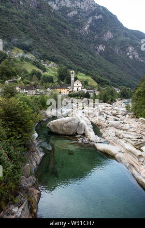 La Valle Verzasca e il fiume, guardando verso la città di Lavertezzo e la sua chiesa di Santa Maria degli Angeli, nel Canton Ticino in Svizzera. Foto Stock