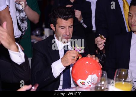 Il portoghese football star Luis Figo del Real Madrid Leyendas, centro autografi su un campo di calcio per i fan cinesi durante una cena di beneficenza parte a Pechino Foto Stock