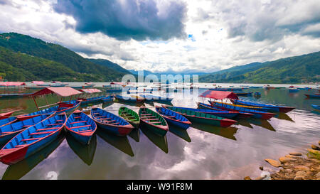 Barche colorate nel lago Phewa un giorno coludy Pokhara Nepal Foto Stock