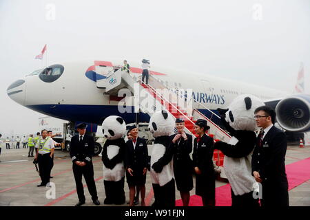 I membri dell'equipaggio di volo BA89 da Londra a Chengdu della British Airways stand nella parte anteriore del velivolo dipinta per assomigliare ad un panda gigante al C Foto Stock