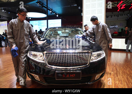 --FILE--lavoratori cinesi polvere fuori una bandiera rossa (Hongqi) H7 di limousine FAW durante il XV Shanghai International Industria Automobilistica Exhibition, noto Foto Stock