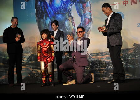 Attore americano Robert Downey Jr (destra 2nd) applaude per un ragazzo (sinistra 2nd) indossando il costume di Iron Man durante una conferenza stampa per promuovere il suo Foto Stock