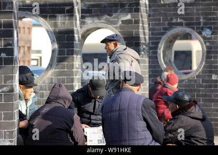 --FILE--anziani residenti cinesi chat per trascorrere il tempo in un parco in Qingdao City East Chinas provincia di Shandong, 2 febbraio 2013. Peo cinese Foto Stock