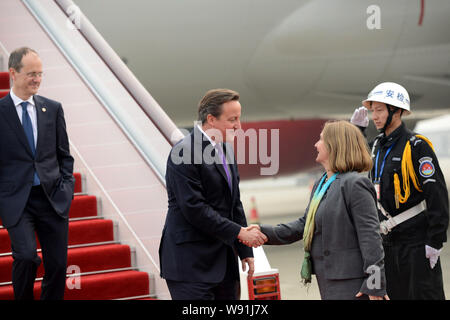 Primo Ministro britannico David Cameron, seconda a sinistra, scuote le mani con una donna dopo essere arrivati a Chengdu Shuangliu International Airport durante il suo Foto Stock