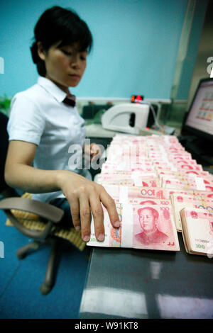 --FILE--un addetto cinese conta RMB (renminbi) presso una filiale di industriale e banca commerciale della Cina (ICBC) in Huaibei, est Chinas provincia di Anhui, 9 Foto Stock