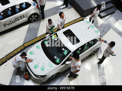 Concorrenti cinesi tenere le mani su una Volkswagen Polo GTI durante una mano-su-auto competizione endurance a Super Brand Mall in Lujiazui finanziario Foto Stock