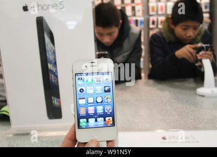 --FILE--un cliente tenta di eseguire un iPhone 4S smartphone a un Apple Store in Xuchang, porcellane centrale provincia di Henan, 15 dicembre 2012. Dopo anni di s Foto Stock