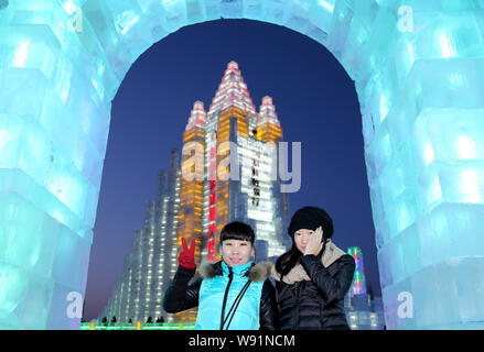 Visitatori posano per le foto di fronte a sculture di ghiaccio al XV di Harbin ed al Mondo del Ghiaccio e della neve nella città di Harbin, nordest Chinas Provincia di Heilongjiang, 29 D Foto Stock