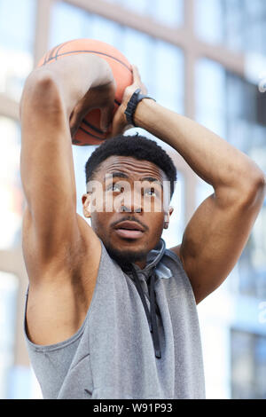 Ritratto di azione dell'Africano del giocatore di basket ball di ripresa durante la pratica in tribunale aperto Foto Stock