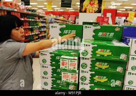 --FILE--un cliente acquista Mengniu puro latte in un supermercato a Qingdao, est Chinas provincia di Shandong, 22 agosto 2012. China Mengniu Dairy, porcellane bi Foto Stock