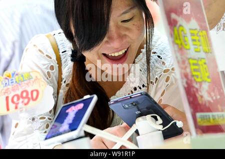 --FILE--un cliente tenta di eseguire un 4G smartphone a un ramo di China Mobile in Hangzhou, est Chinas nella provincia di Zhejiang, 28 settembre 2013. La Cina ha aw Foto Stock