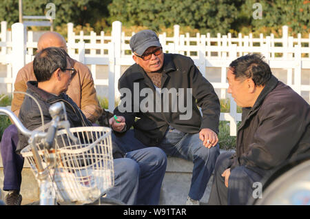 --FILE--anziani residenti cinesi chat per trascorrere il tempo in un parco nella città di Xuchang, porcellane centrale provincia di Henan, 17 novembre 2013. Pe cinese Foto Stock