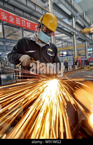 --FILE--un lavoratore cinese lucidanti prodotti di acciaio presso lo stabilimento di Nantong Guosheng macchinari & Power-Generating Group Co., Ltd. nella città di Nantong, EST C Foto Stock