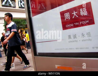 --FILE--pedoni a piedi passato un annuncio di Chow Tai Fook in Cina a Shanghai, 10 settembre 2011. Chow Tai Fook Jewellery Group Ltd., i mondi Foto Stock