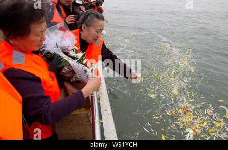 Persone diffuse petali di fiori durante un mare cerimonia funebre su una nave nella città di Wenzhou, est Chinas nella provincia di Zhejiang, 30 marzo 2012. Foto Stock