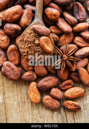 Le fave di cacao e polvere di cacao su un vecchio sfondo di legno Foto Stock