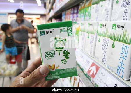 --FILE--un cinese cliente acquista un cartone di latte Mengniu in un supermercato in Xuchang, porcellane centrale provincia di Henan, 22 giugno 2013. Il Inner-Mongol Foto Stock