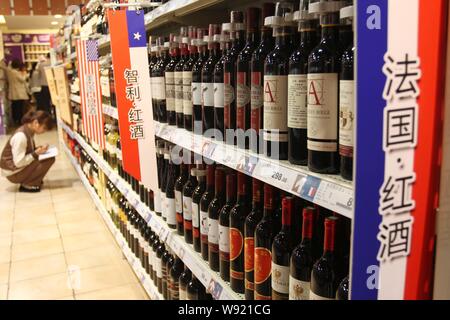 --FILE--bottiglie di vino importato dalla Francia, il Cile e gli Stati Uniti sono esposti per la vendita ad un supermercato in Xuchang, central Chinas Henan pro Foto Stock