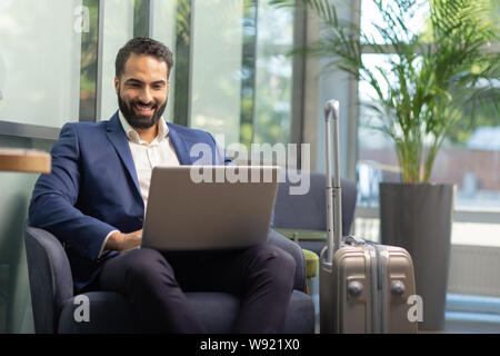 Positivo il piacere bruna persona di sesso maschile per leggere le notizie Foto Stock