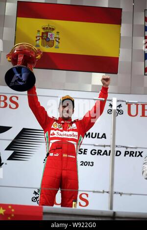 Spagnolo di F1 driver Fernando Alonso della Ferrari celebra con il suo campione del trofeo dopo la vittoria del 2013 Formula Uno Gran Premio di Cina a Shanghai Foto Stock