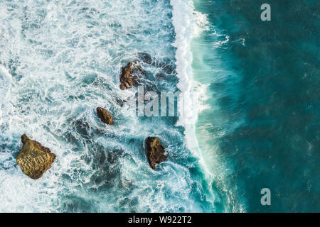 Vista aerea delle onde che si infrangono sulle rocce. Vista da sopra, drone foto, bellissima natura sfondo Foto Stock