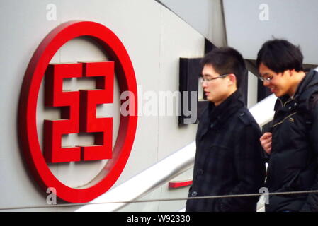 --FILE--pedoni a piedi passato una segnaletica di ICBC (industriale e banca commerciale della Cina) in Cina a Shanghai, 21 febbraio 2013. Per la prima volta Foto Stock