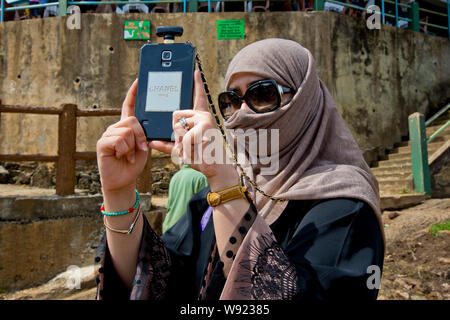 Donna che indossa un velo NIQAB E UNO SMARTPHONE IN SRI LANKA Foto Stock