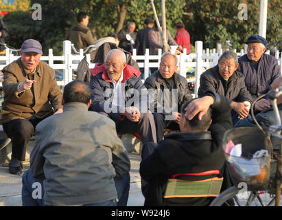 --FILE--anziani residenti cinesi chat per trascorrere il tempo in un parco nella città di Xuchang, porcellane centrale provincia di Henan, 17 novembre 2013. Pe cinese Foto Stock