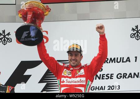 Spagnolo di F1 driver Fernando Alonso della Ferrari celebra con il suo campione del trofeo dopo la vittoria del 2013 Formula Uno Gran Premio di Cina a Shanghai Foto Stock