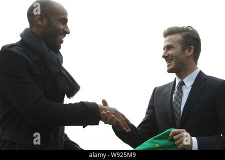 Inglese soccer superstar David Beckham, destra stringe la mano con il calciatore francese Frederic Kanoute di porcellane Pechino Guoan Football Club come Beckham ho Foto Stock