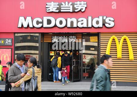 --FILE--pedoni a piedi passato un ramo del McDonalds un fast food ristorante nella Città di Zhengzhou, porcellane centrale provincia di Henan, 26 ottobre 2013. McDonalds Foto Stock