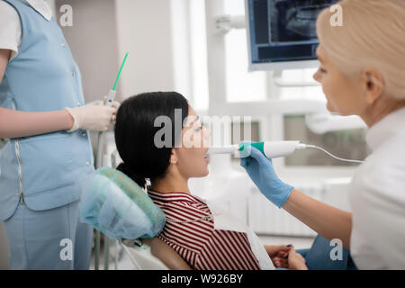 Giovane donna con il suo trattamento dentale visitando il suo dentista. Foto Stock