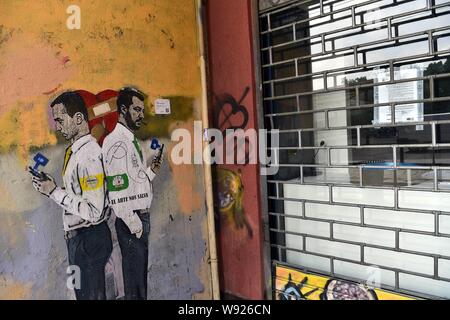 Porta Ticinese, il design dei TV ragazzo con Luigi Di Maio e Matteo Salvini con alle loro spalle e tenendo premuto il loro telefono cellulare (Duilio Piaggesi/fotogramma, Milano - 2019-08-12) p.s. la foto e' utilizzabile nel rispetto del contesto in cui e' stata scattata, e senza intento diffamatorio del decoro delle persone rappresentate Foto Stock