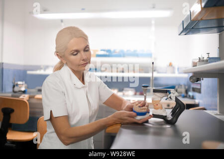 Odontotecnico cerca problemi nel cast modello di denti. Foto Stock