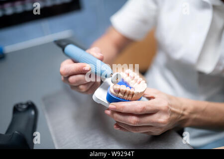 Protesi dentarie in mani di odontotecnico. Foto Stock