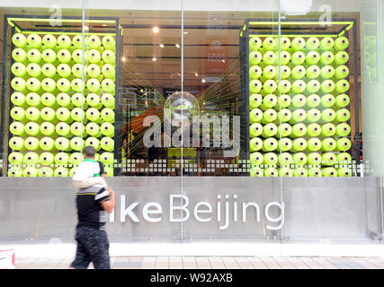 --FILE - Passeggiate a piedi passato il flagship store di Nike in area per lo shopping di Wangfujing di Pechino, Cina, 27 agosto 2012. Nikes flagship store nel Beij Foto Stock