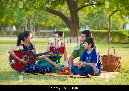 Famiglia che ha pic-nic in un parco Foto Stock