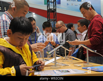 I visitatori di provare nuovi smartphone durante la XV China Hi-tech Fair (CHTF) a Shenzhen, sud Chinas nella provincia di Guangdong, 17 novembre 2013. Il numbe Foto Stock