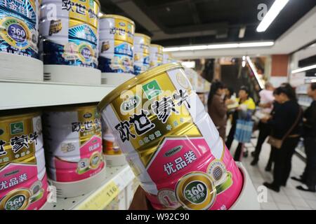 --FILE--un cliente acquista una lattina di Mengniu Arla il latte in polvere in un supermercato in Xuchang, porcellane centrale provincia di Henan, 19 ottobre 2013. Cina Mengniu Foto Stock