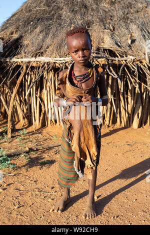 Turmi, Omo River Valley, Etiopia - 10 Maggio 2019: Ritratto di Hamar bambini nel villaggio. Gli Hamer sono una tribù primitiva e le donne hanno molti dec Foto Stock